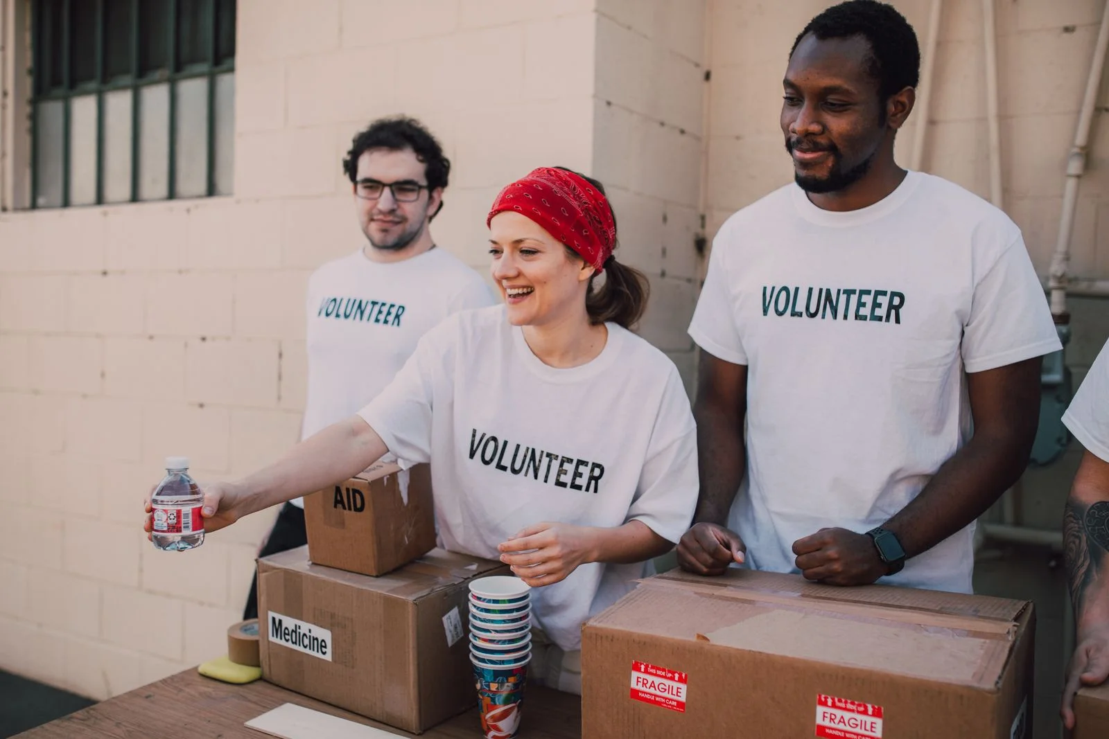Volunteers standing together beside boxes of donated supplies